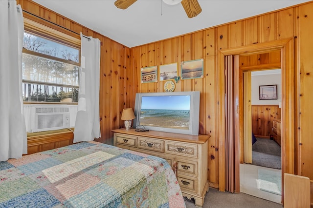 carpeted bedroom with cooling unit, wooden walls, and ceiling fan