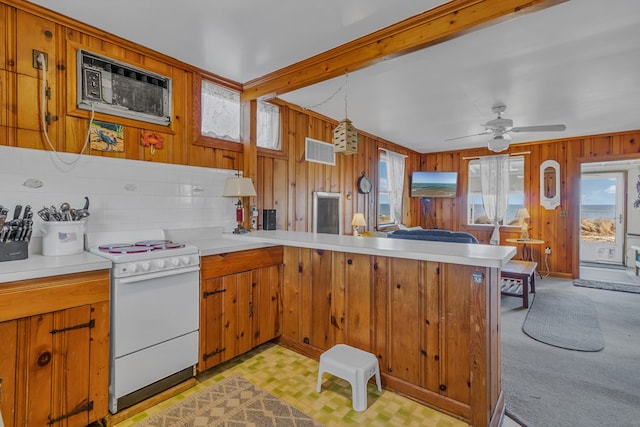 kitchen with white stove, pendant lighting, wood walls, kitchen peninsula, and beam ceiling