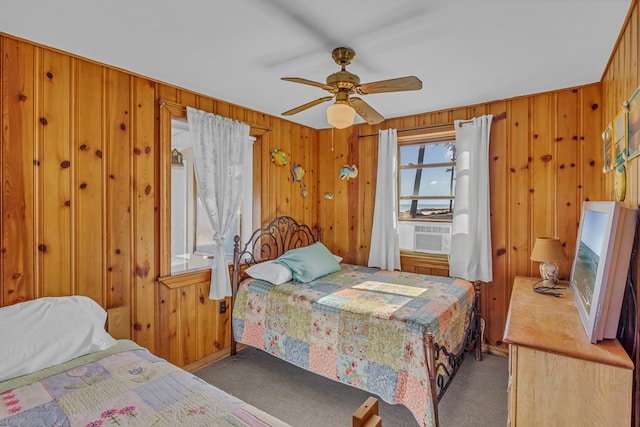 bedroom with cooling unit, wood walls, ceiling fan, and carpet