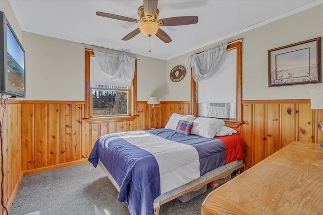 carpeted bedroom featuring cooling unit, crown molding, multiple windows, and wood walls