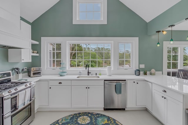 kitchen featuring kitchen peninsula, stainless steel appliances, sink, white cabinets, and lofted ceiling