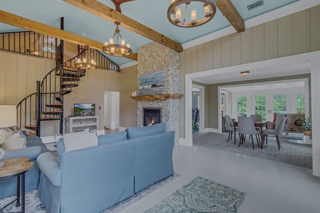 living room with a large fireplace, beamed ceiling, high vaulted ceiling, a notable chandelier, and wooden walls