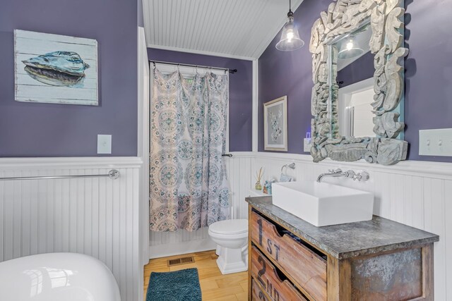 bathroom with vanity, toilet, wood-type flooring, and crown molding