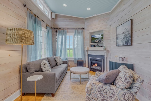 living room with wooden walls, plenty of natural light, and light wood-type flooring