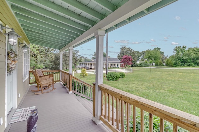 deck featuring a yard and covered porch