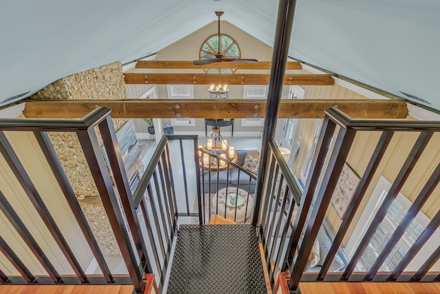 stairway with hardwood / wood-style flooring, lofted ceiling, and a chandelier