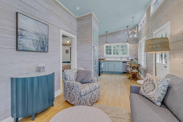 living room with wooden walls, light hardwood / wood-style flooring, lofted ceiling, and crown molding