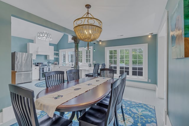 dining space with sink, lofted ceiling with beams, and an inviting chandelier