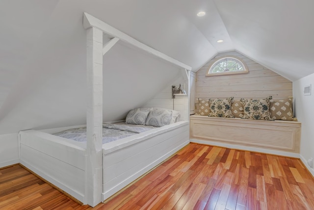 bedroom with wood-type flooring and vaulted ceiling