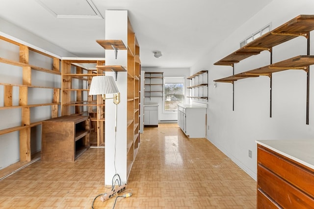 interior space featuring a baseboard heating unit, open shelves, and light countertops