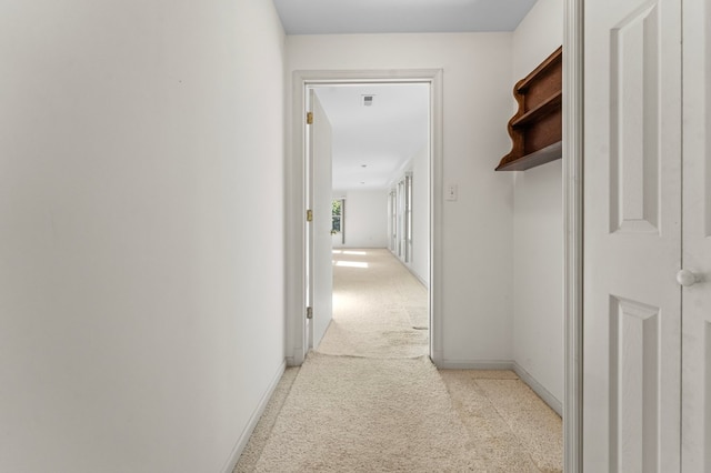 hallway with light carpet and baseboards