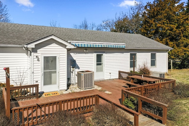 back of house with a deck, central AC unit, and roof with shingles