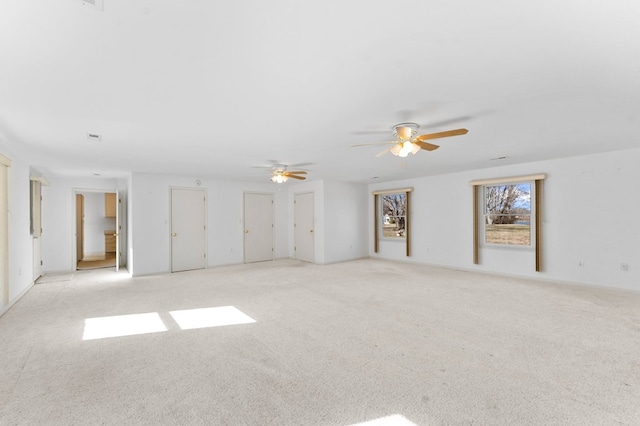 empty room featuring a ceiling fan and light colored carpet