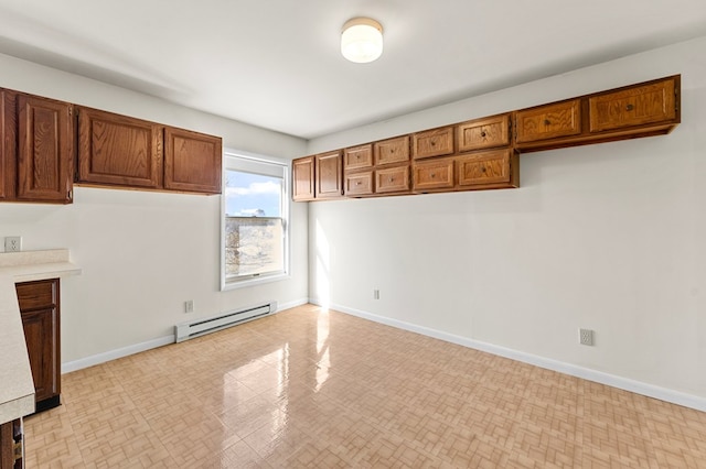 interior space with brown cabinetry, baseboards, baseboard heating, and light countertops