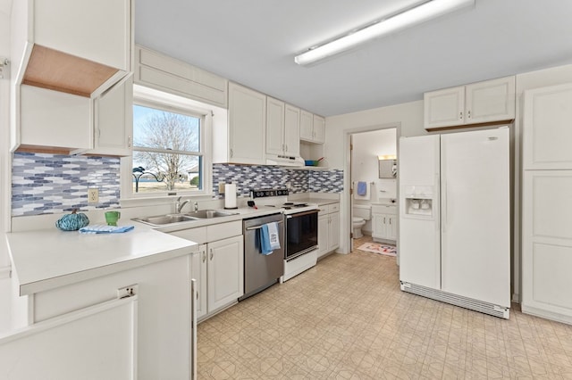 kitchen featuring white appliances, a sink, white cabinetry, light countertops, and light floors