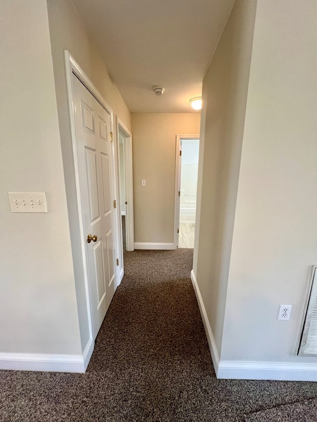 hall featuring dark colored carpet