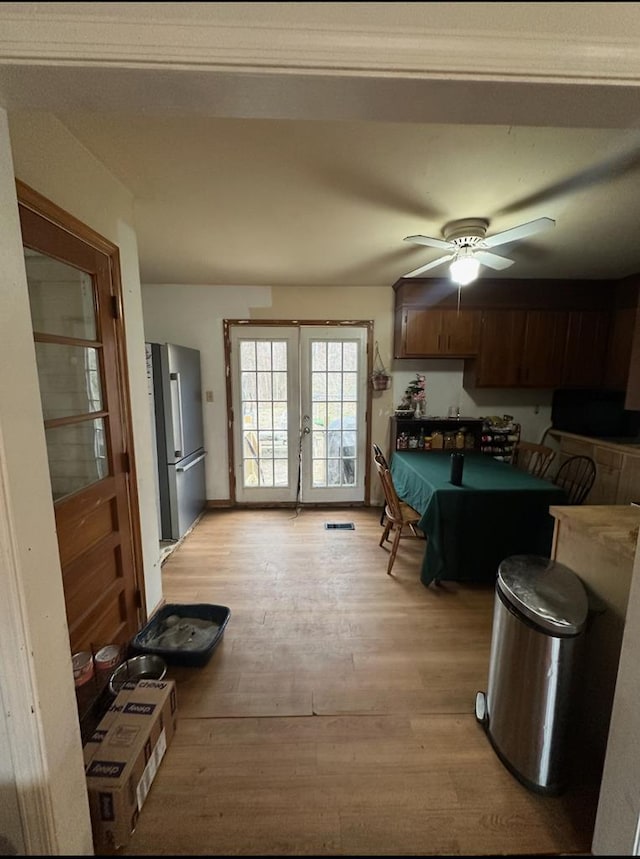 kitchen with light wood finished floors, french doors, freestanding refrigerator, and a ceiling fan