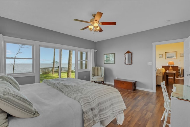 bedroom featuring a water view, ceiling fan, dark hardwood / wood-style floors, and access to outside