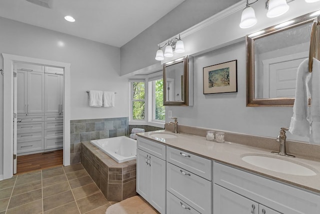 bathroom with vanity, a relaxing tiled tub, and tile patterned floors