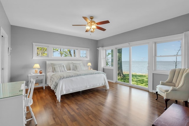 bedroom featuring a water view, ceiling fan, access to exterior, and dark wood-type flooring