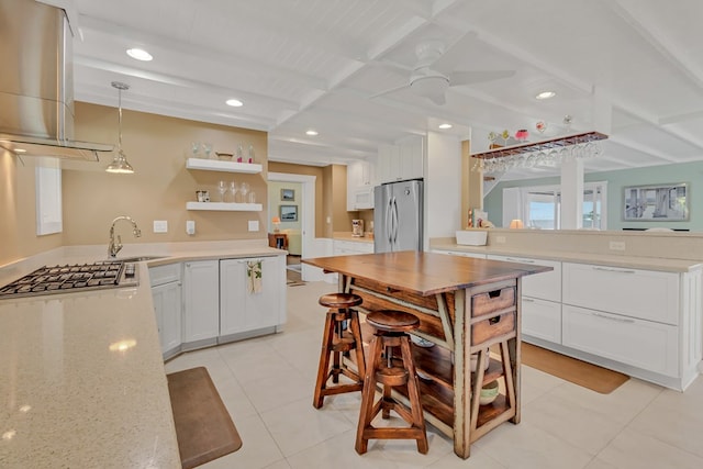 kitchen featuring sink, white cabinetry, stainless steel appliances, decorative light fixtures, and kitchen peninsula