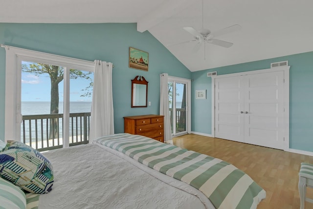 bedroom with vaulted ceiling with beams, a water view, ceiling fan, access to exterior, and light hardwood / wood-style floors