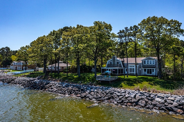 back of property featuring a lawn and a water view