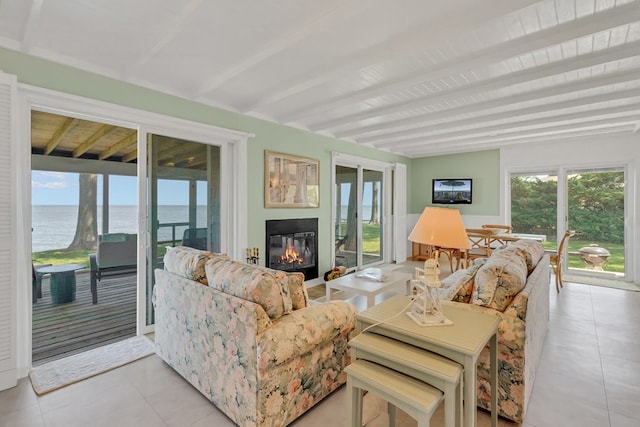 sunroom with a water view, a wealth of natural light, and beam ceiling