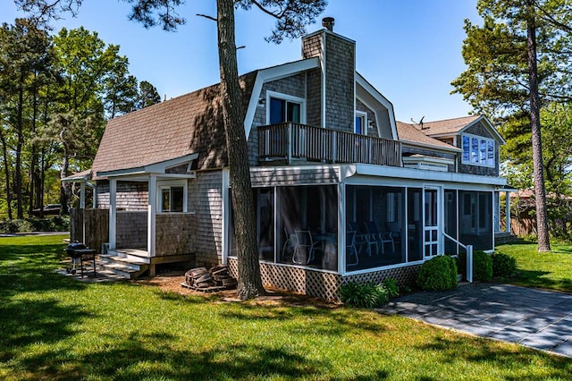 rear view of property with a sunroom and a lawn