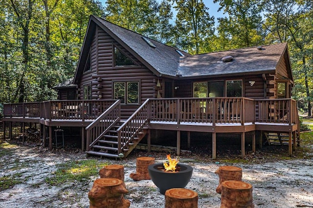 rear view of house with a fire pit and a deck