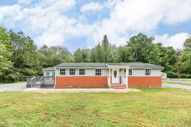 single story home with a wooden deck and a front lawn