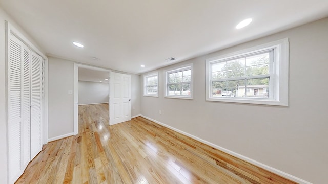 unfurnished bedroom with a closet and light wood-type flooring