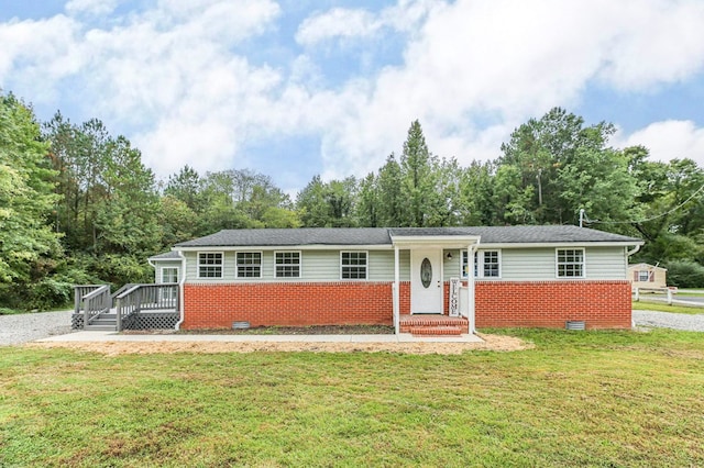 ranch-style house with a wooden deck and a front lawn