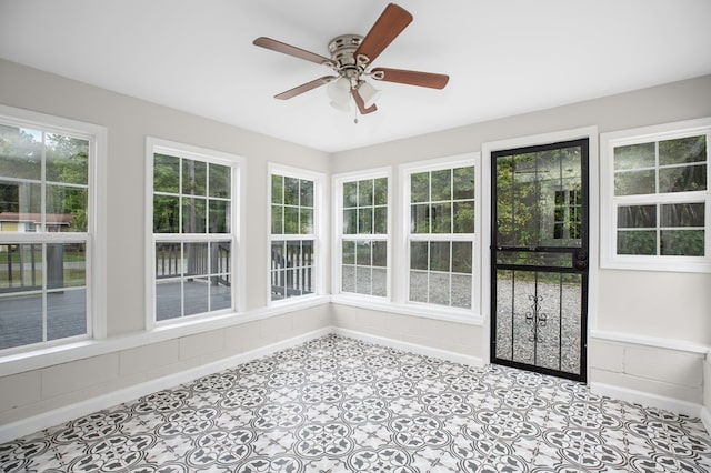 unfurnished sunroom with ceiling fan