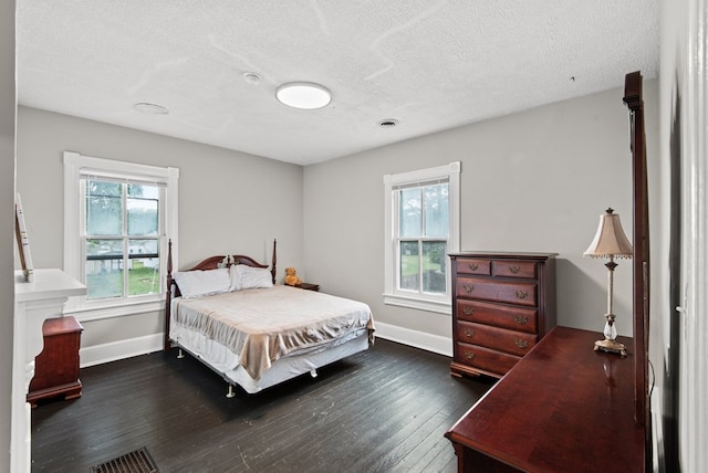 46 Yeocomico Ln, Kinsale, VA 22488 - bedroom with multiple windows, baseboards, dark wood-style floors, and a textured ceiling