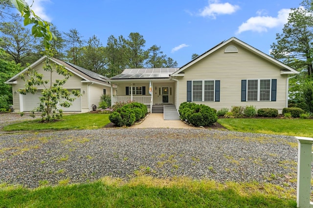 586 Kingscote Dr, Lottsburg, VA 22511 - ranch-style home featuring covered porch, roof mounted solar panels, a garage, a front lawn, and driveway