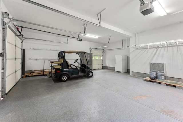 586 Kingscote Dr, Lottsburg, VA 22511 - garage with a garage door opener and freestanding refrigerator