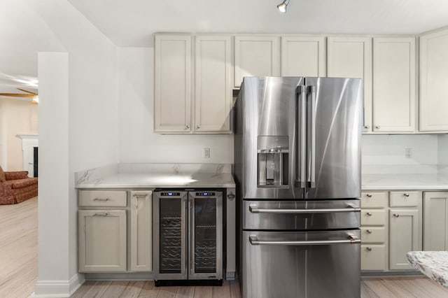 586 Kingscote Dr, Lottsburg, VA 22511 - kitchen with stainless steel fridge, beverage cooler, light wood-style floors, and a fireplace