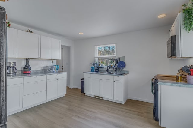 427 Brooks Ln, Callao, VA 22435 - kitchen with white cabinetry, sink, light hardwood / wood-style floors, and range