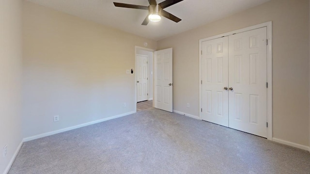 unfurnished bedroom with ceiling fan, light colored carpet, and a closet