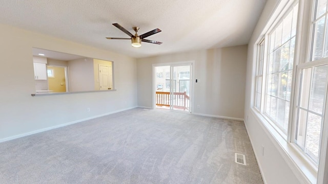 carpeted empty room with a textured ceiling and ceiling fan