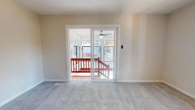 carpeted empty room featuring ceiling fan and a textured ceiling