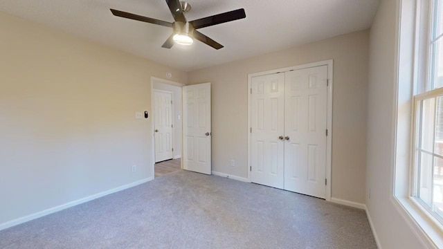 unfurnished bedroom with ceiling fan, a closet, and light colored carpet