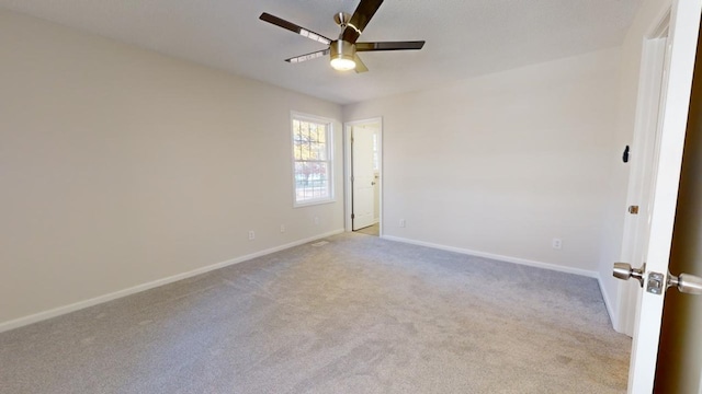 carpeted spare room featuring ceiling fan