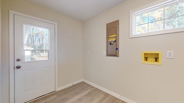 entryway with light wood-type flooring, electric panel, and a healthy amount of sunlight