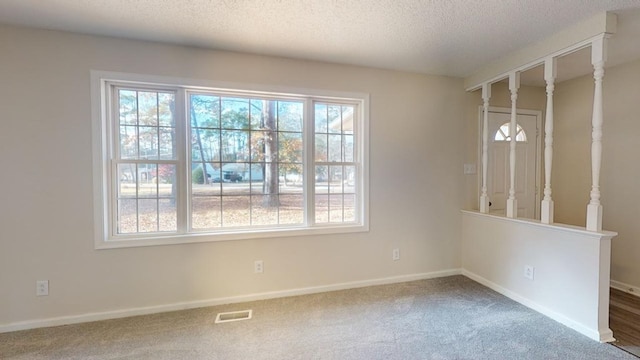 unfurnished dining area featuring carpet and a textured ceiling