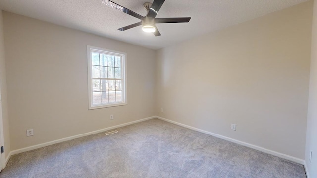 carpeted empty room with ceiling fan and a textured ceiling