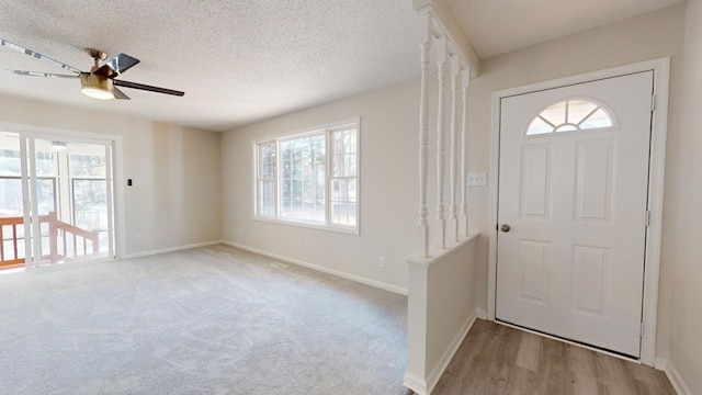 foyer entrance featuring a textured ceiling, ceiling fan, and a healthy amount of sunlight