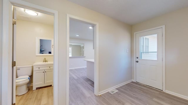 foyer entrance with a textured ceiling and light wood-type flooring