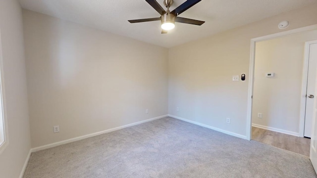 empty room featuring ceiling fan and light colored carpet